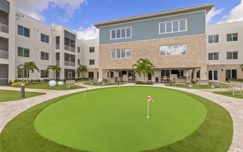 Beautiful putting green at Aviva Port St. Lucie with manicured landscaping and seating areas for relaxation.